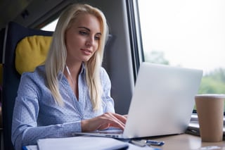 Employee using business application on laptop while travelling