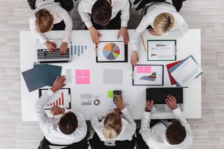 Marketing team planning campaign with charts and laptops