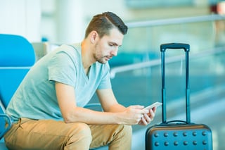 Traveller checking booking details on smartphone in hotel lobby